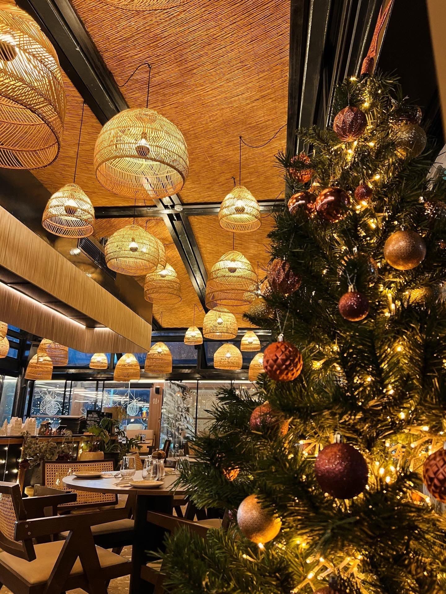 Klay's dining room dressed for Christmas beneath glowing rattan lamps