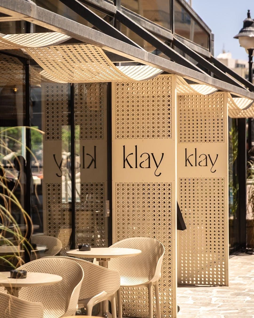 Klay's entrance on the Balluta promenade, with latticed Klay panels and terrace chairs