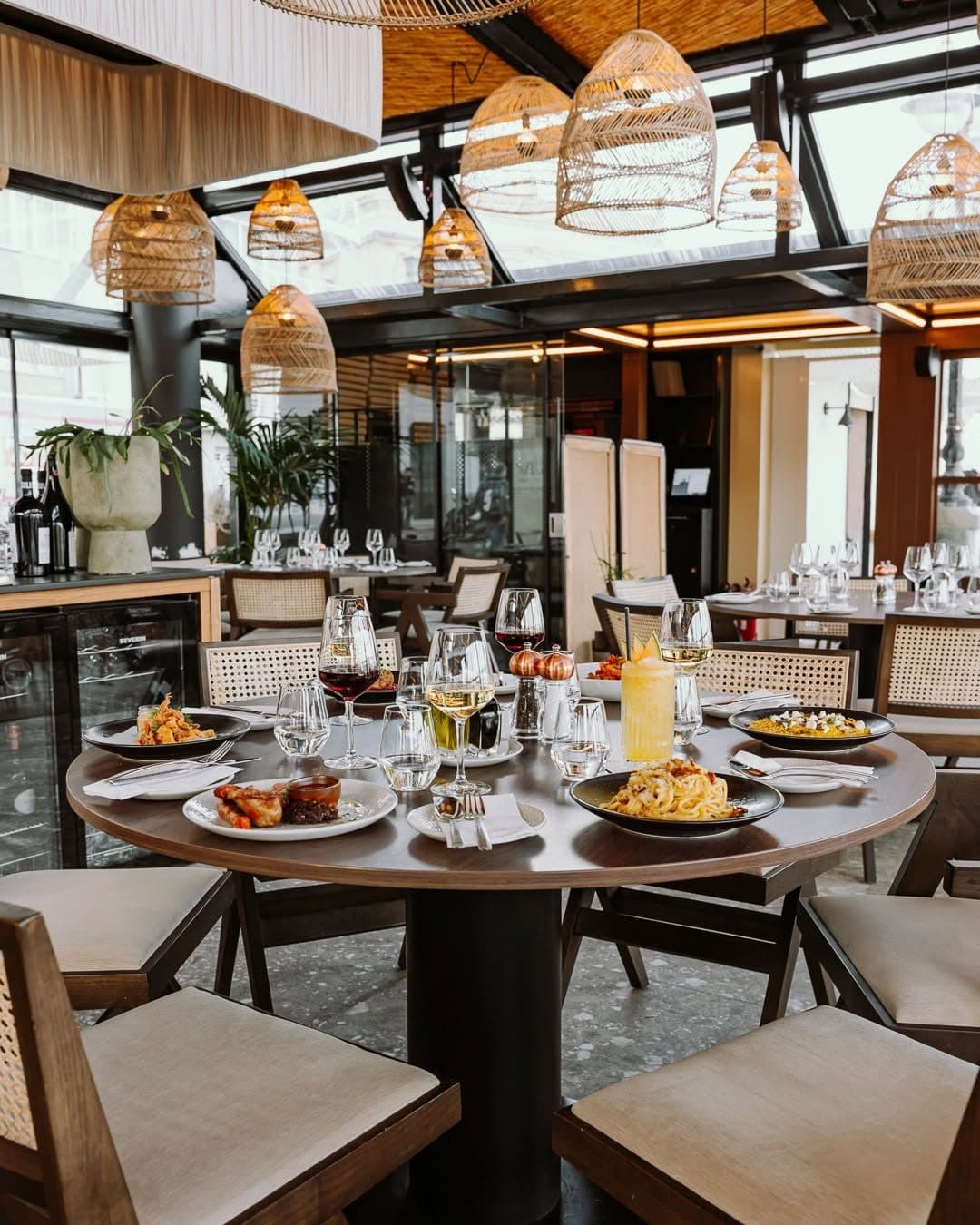 Klay's dining room at night beneath woven rattan pendant lamps