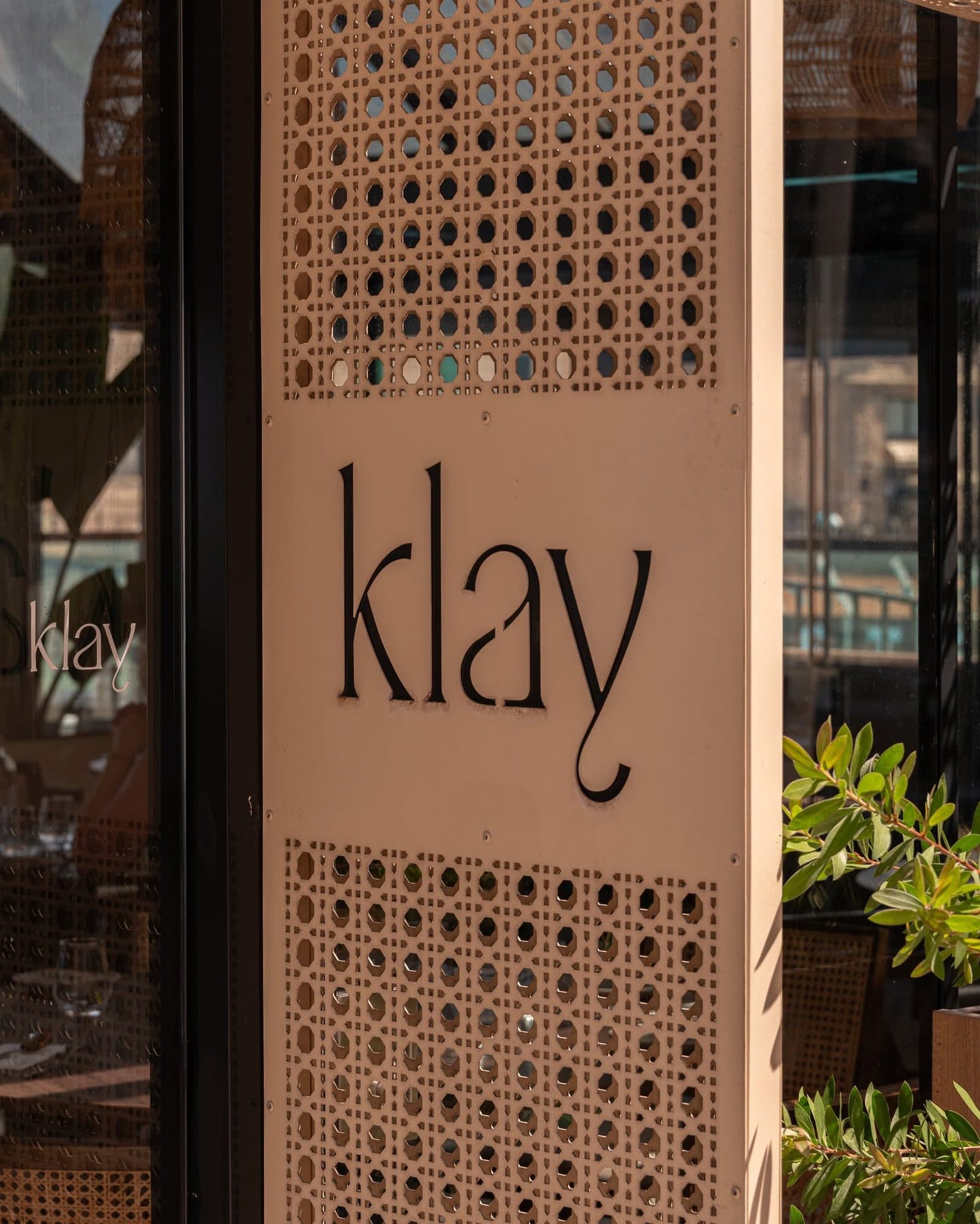 The Klay wordmark on a latticed pillar at the entrance