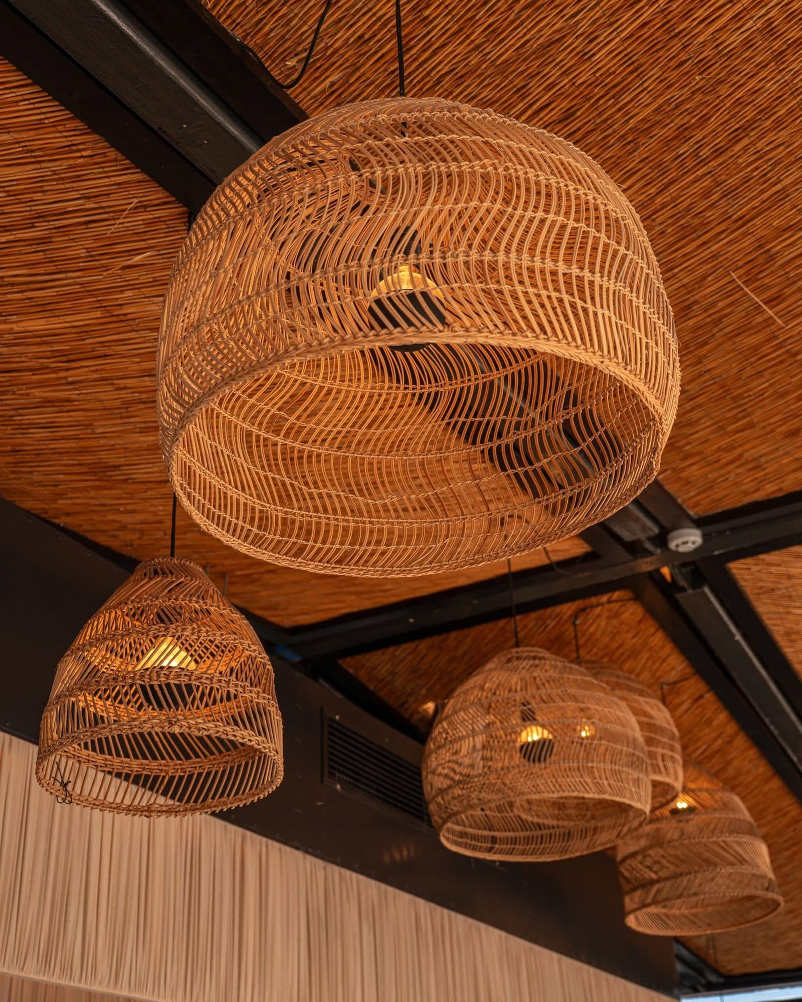 Rattan lampshades against the reed ceiling